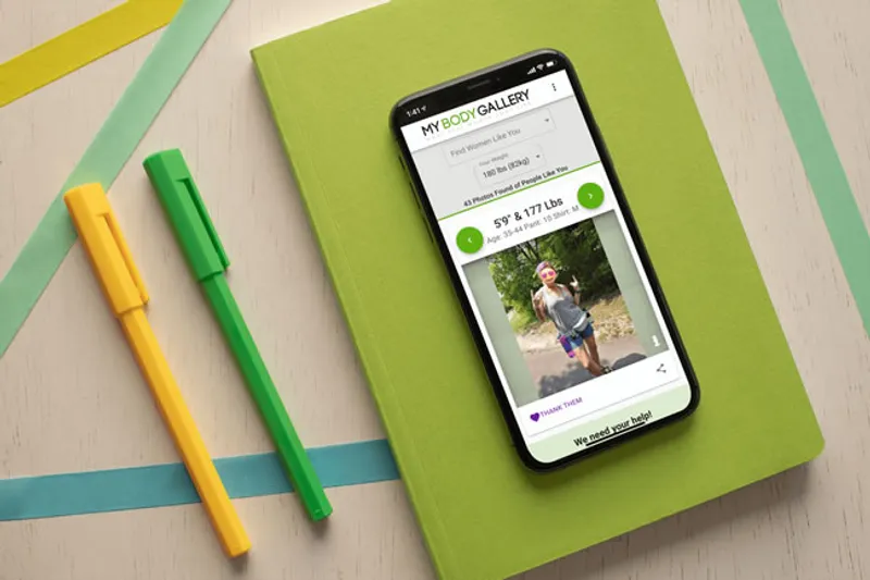 Phone on top of a green book display a young woman's profile on My Body Gallery app.